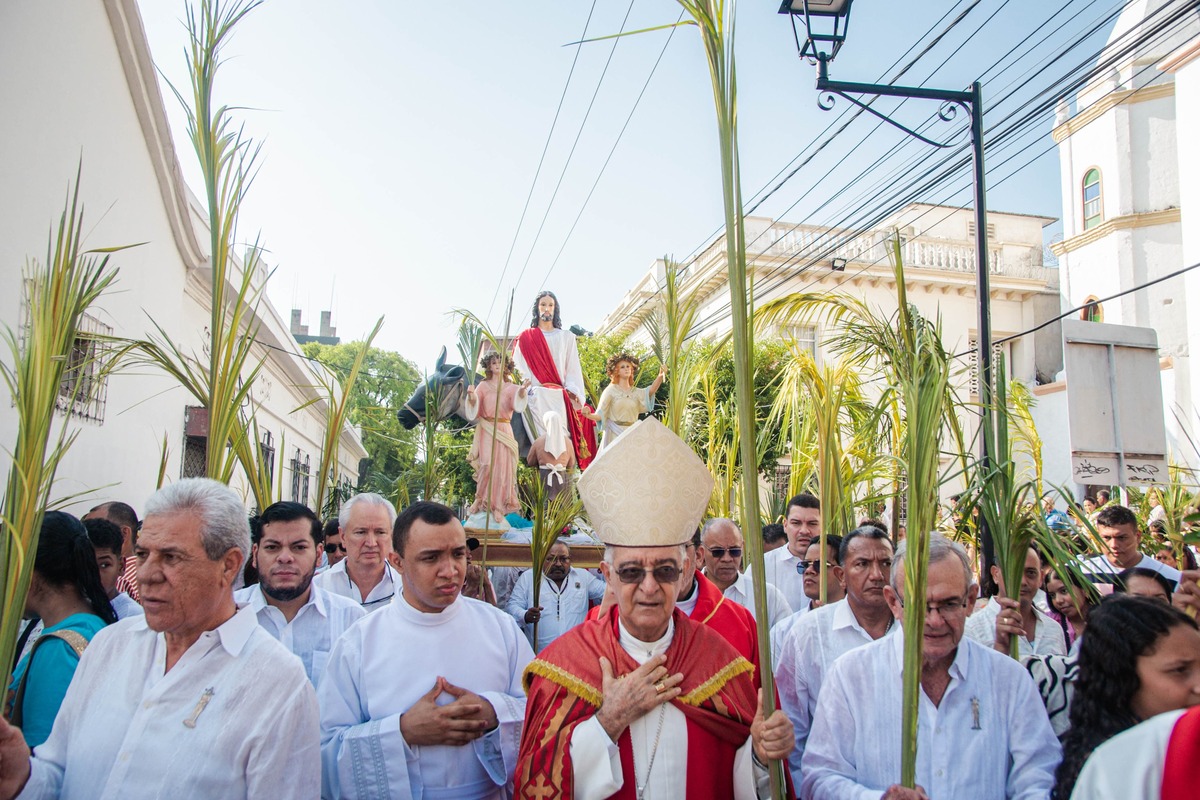 Monseñor Óscar José Vélez Isaza, obispo de la Diócesis de Valledupar, preside la procesión del Domingo de Ramos, acompañado por fieles portando ramas de palmera y árboles típicos, en el centro histórico de Valledupar. Foto: Jesús Ochoa.