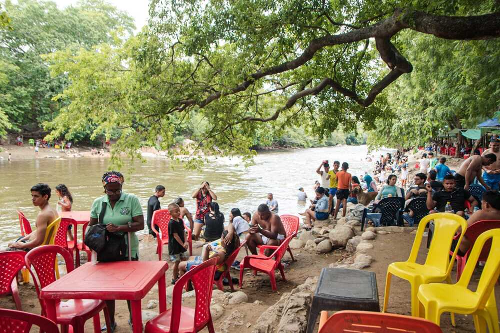 A falta de energía y agua, las familias llevan frutas y agua al río Guatapurí, convirtiendo sus orillas en un refugio temporal contra las adversidades del apagón. Foto: Jesús Ochoa.