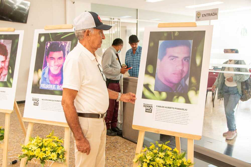 Familiares de víctimas observan con emoción y respeto las fotografías de sus seres queridos en la Galería de Memoria, un espacio para honrar su lucha y preservar la verdad durante la Semana por la Paz. Foto: Gobernación del Cesar.