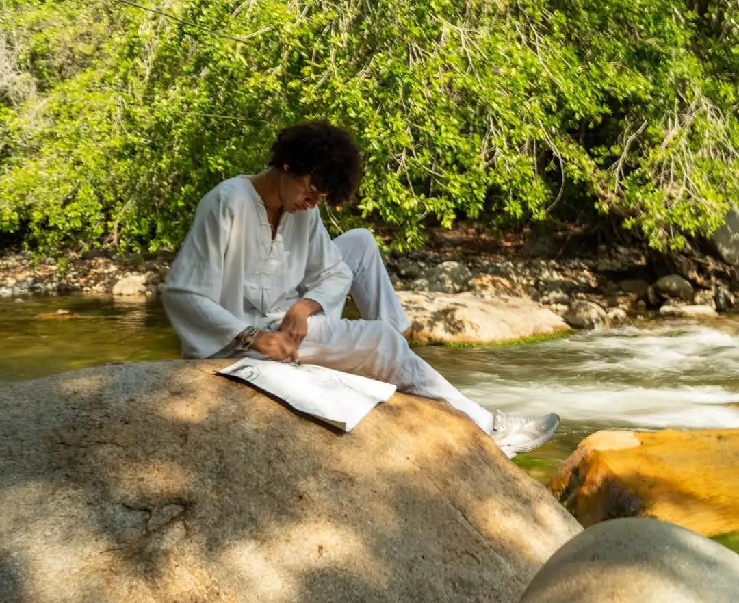 Perkys recolectando pigmentos naturales en el río junto a la comunidad kankuama. Foto: Perkys.