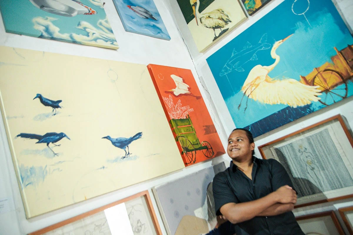 Egling Meriño junto a su serie “De la canoa a la mesa”, inspirada en los oficios del Caribe y el mercado de Basurto, expuesta en el marco de la Feria de Arte de Valledupar ARTVA 2025 “Mundos Próximos”.Foto: Jesús Ochoa.