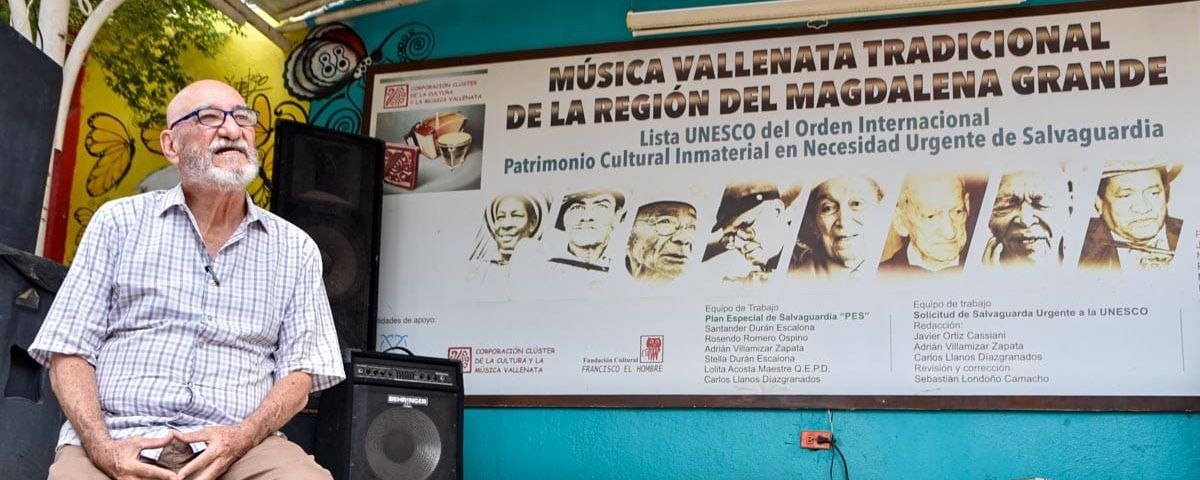Carlos Llanos, coordinador del equipo que impulsó la candidatura del vallenato tradicional ante la Unesco. Al fondo, el afiche que celebra la inclusión de la música vallenata en la lista de Patrimonio Cultural Inmaterial en Necesidad de Salvaguardia Urgente. Foto: Jesús Ochoa.