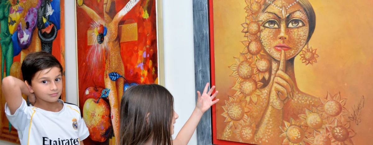 Niños observan las obras expuestas en ARTVA durante su recorrido por la feria.