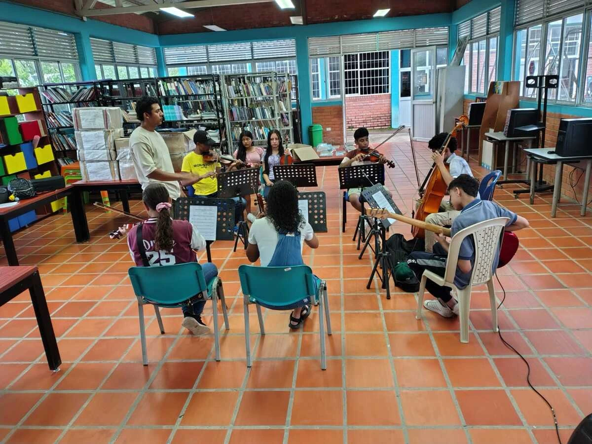 Niños arhuacos de la Filarmónica Infantil de Pueblo Bello ensayan con violines Greco y tambores indígenas, fusionando sinfónica y tradición ancestral en la Sierra Nevada. Foto: Cortesía.