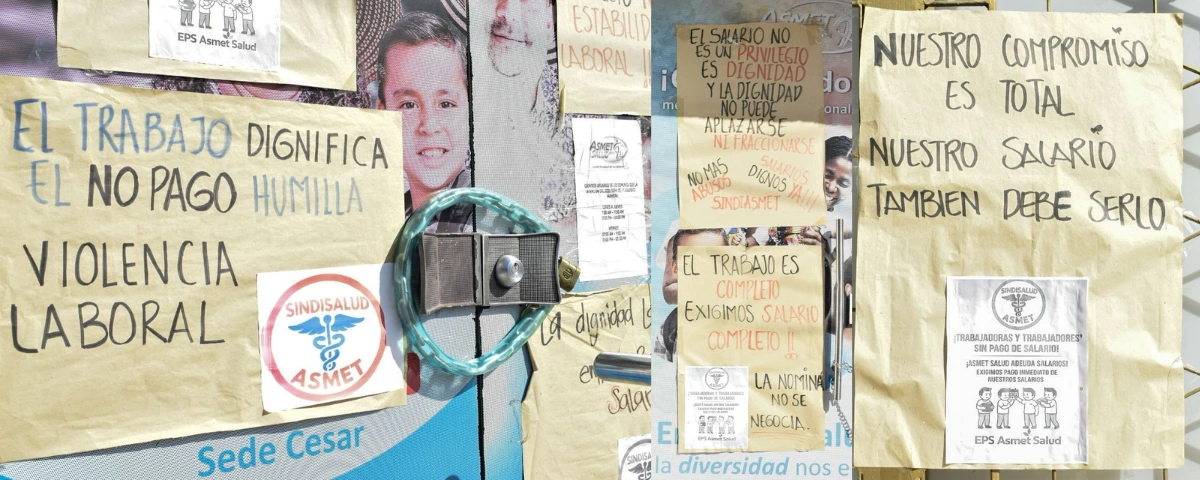 Pancartas pegadas en la fachada de la sede de Asmet Salud en Valledupar denuncian salarios atrasados y exigen soluciones. Foto: Said Armenta.