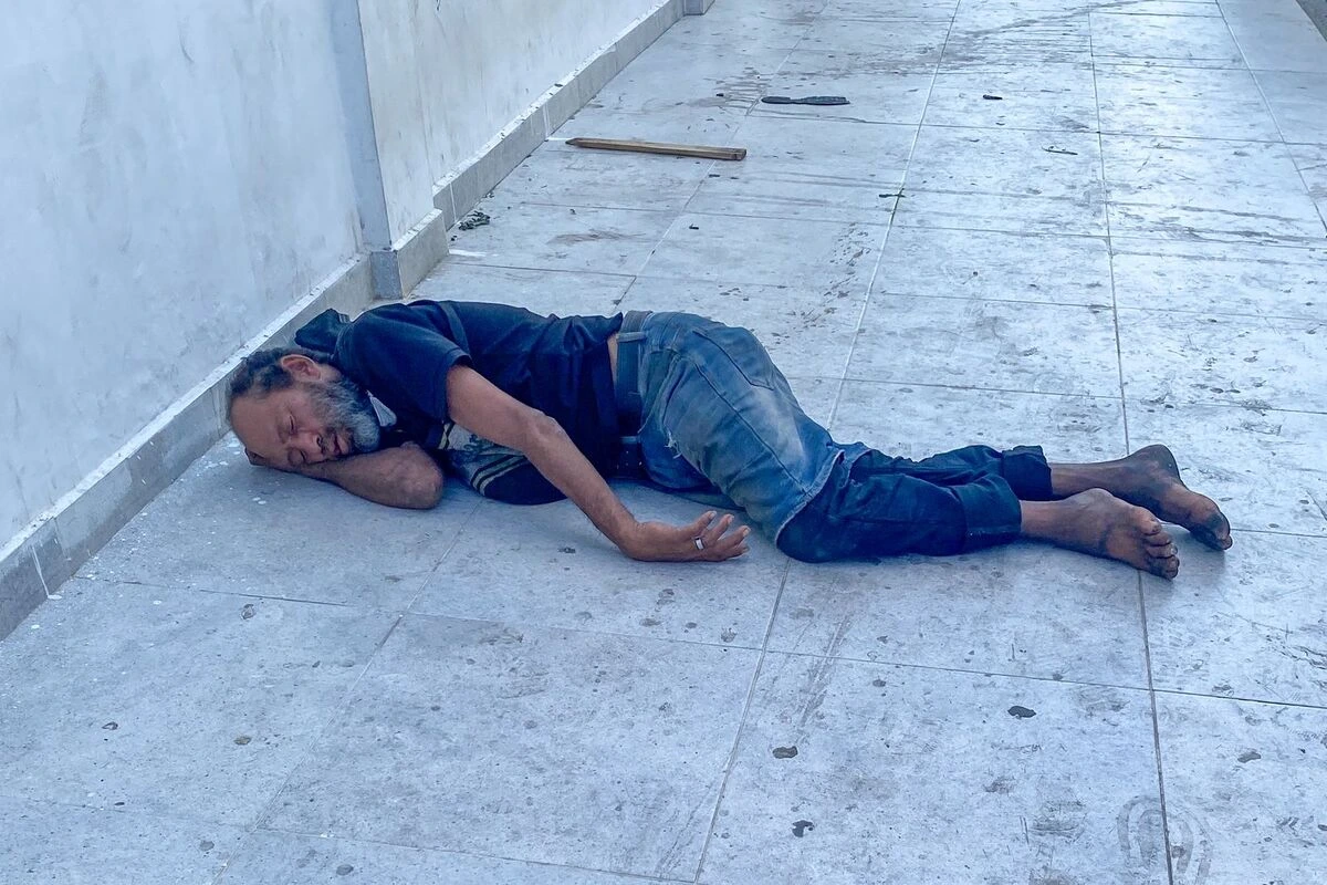 Un adulto mayor en situación de calle descansa, integrado al paisaje urbano, mientras la ciudad sigue de largo sin mirarlo. Foto: Said Armenta.