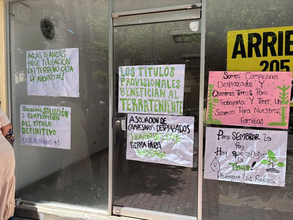 Pancartas y banderas colgadas en las fachadas de los edificios frente a la Caja Agraria visibilizan las denuncias de incumplimiento en la entrega de tierras y el llamado de las comunidades campesinas a que se respeten los acuerdos firmados con la Agencia Nacional de Tierras. Foto: EL PILÓN