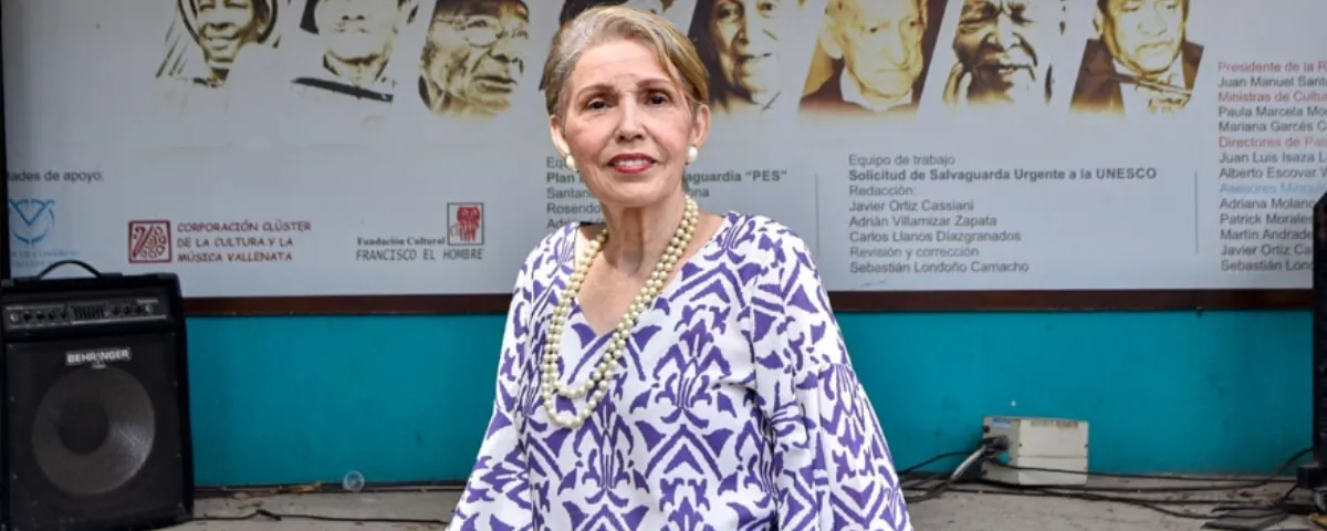 Estela Durán Escalona, intérprete del vallenato tradicional y parte del equipo que elaboró el dossier técnico para la declaratoria de la Unesco, frente al afiche que conmemora los 10 años de reconocimiento mundial