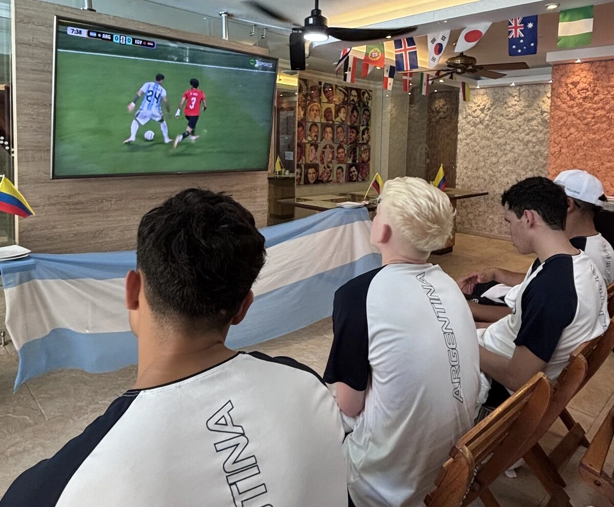 Jugadores de la selección argentina de Goalball, Los Topos, se ubican en primera fila frente al televisor del Tativán para vivir el duelo ante Egipto como si estuvieran en la tribuna. Foto: EL PILÓN.